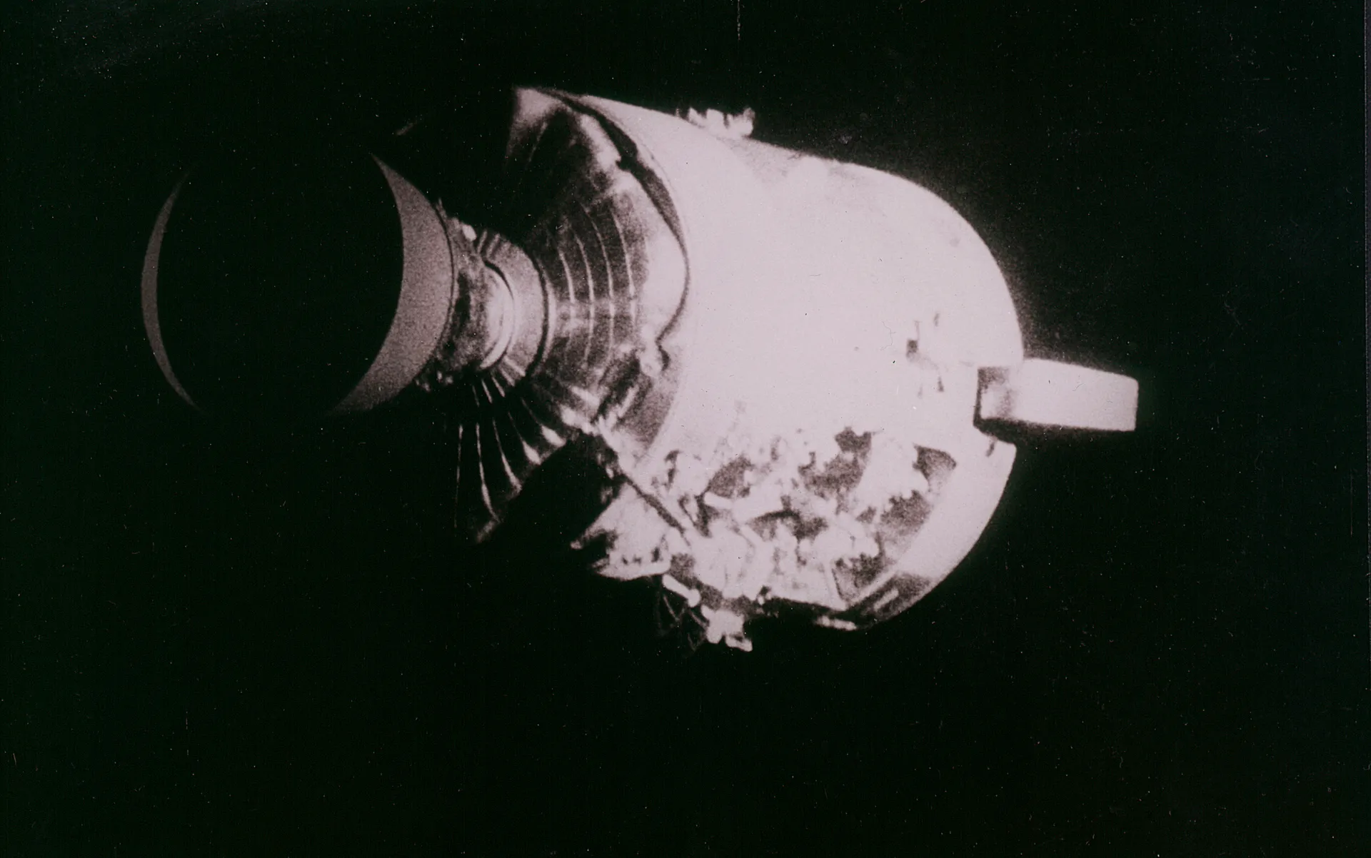 The jettisoned Apollo 13 service module, with one side panel blown away.