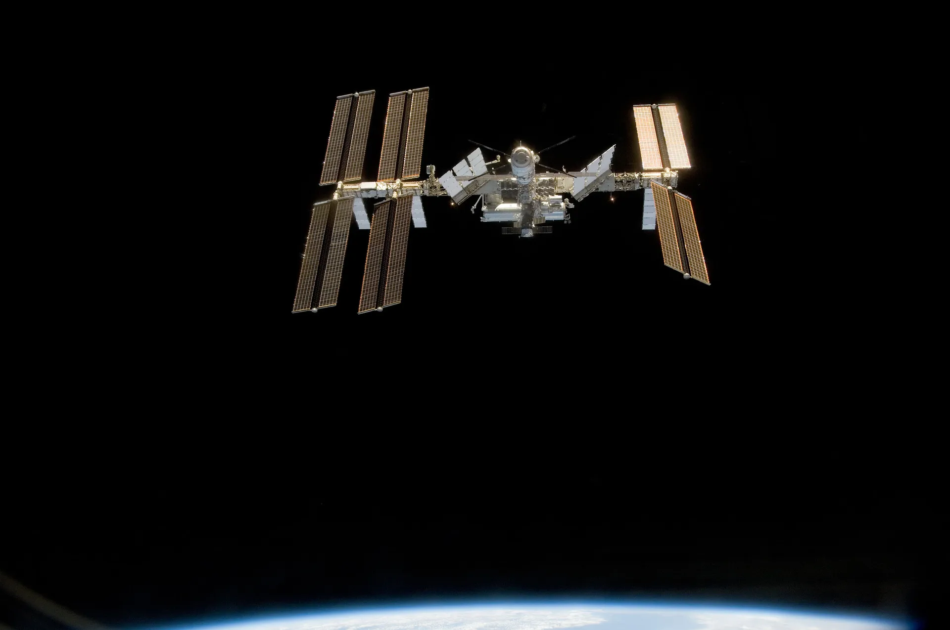 The station against black space with four solar-array wings and a cluster of modules.